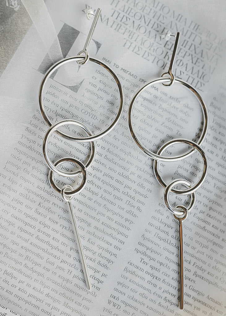 Tantra. Pendant earrings, consisting of three, different sized, interlocked links and a dangling pin
