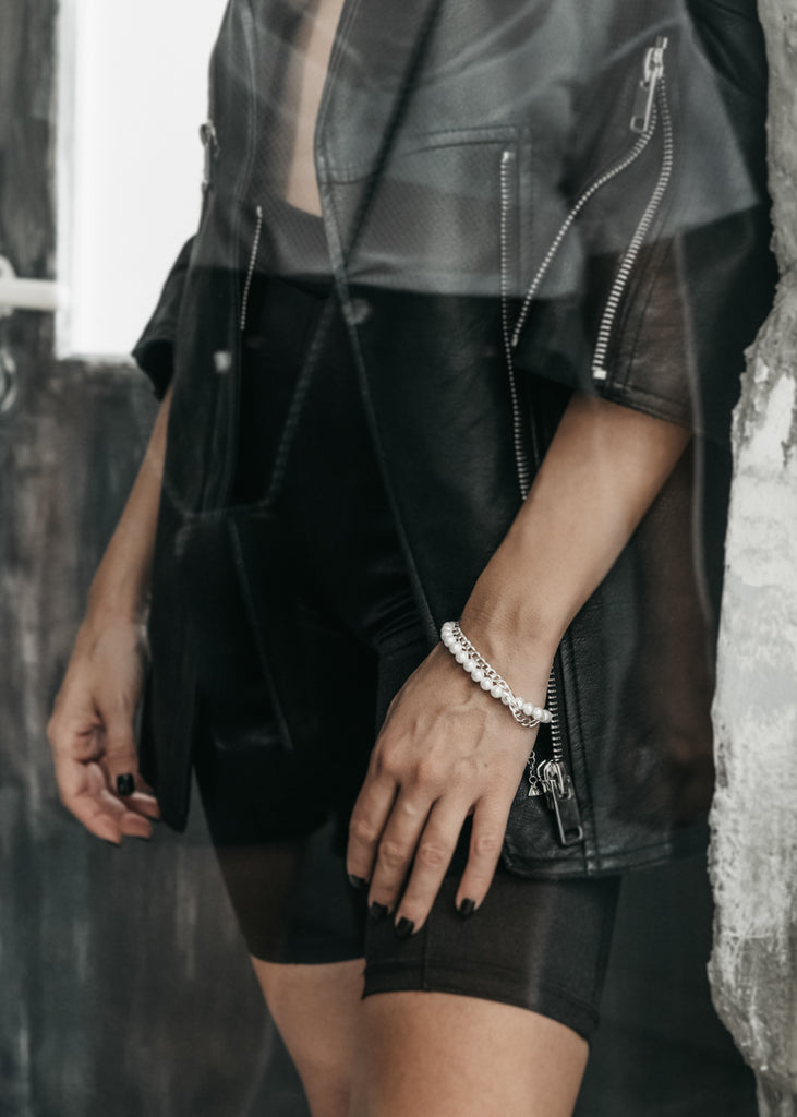  female hand wearing a silver chain and pearls bracelet by 3rd Floor