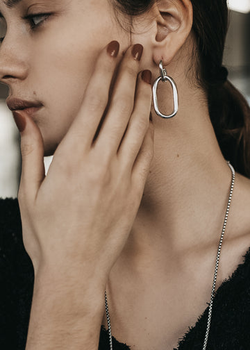 model with Massive, loop chain earrings, in silver 