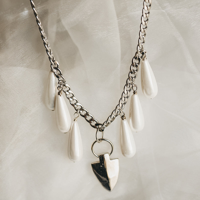 Silver, chain necklace, with dangling pearl tears and a shield shaped festoon