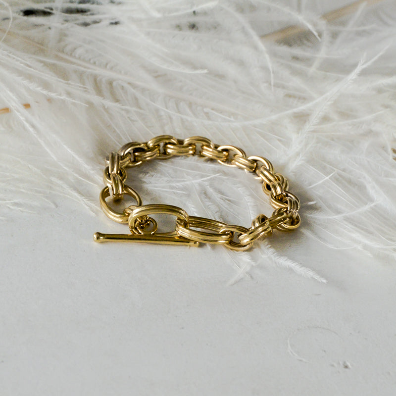 Zola. Gold plated, double link, chain bracelet, placed on white feathers. Χειροποίητο Βραχιόλι Zola Χρυσό