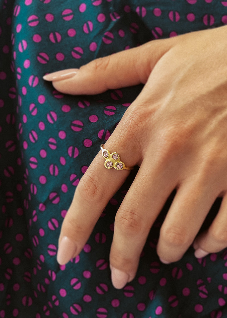 Χειροποίητο δαχτυλίδι Eday χρυσό με τέσσερεις πέτρες Swarovski ροζ, φορεμένο στο χέρι μοντέλου.