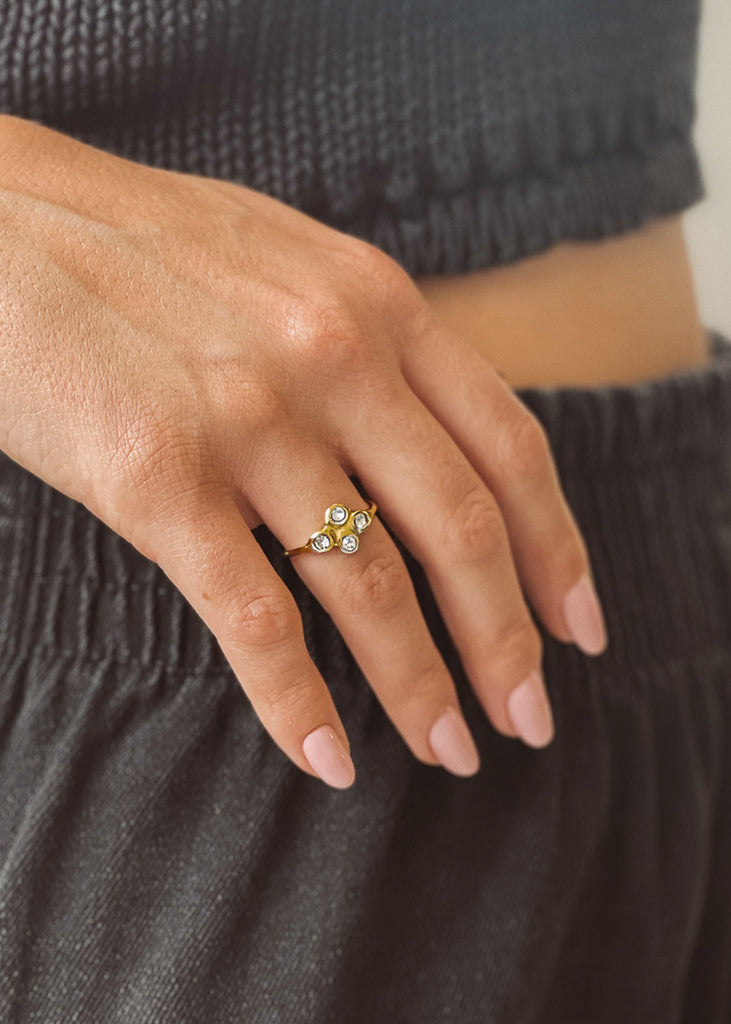 Χειροποίητο δαχτυλίδι Eday χρυσό με τέσσερεις πέτρες Swarovski διάφανες, φορεμένο στο χέρι μοντέλου.