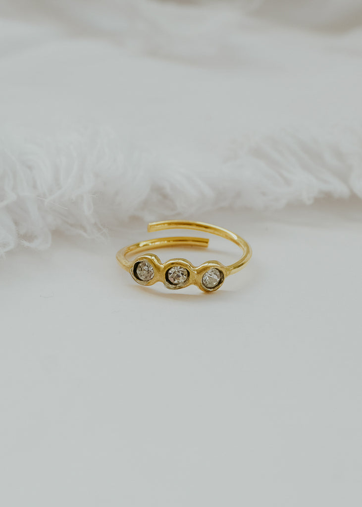 Δαχτυλίδι χειροποίητο χρυσό από ασήμι, με τρεις πέτρες Swarovski διάφανες σε λευκό φόντο.