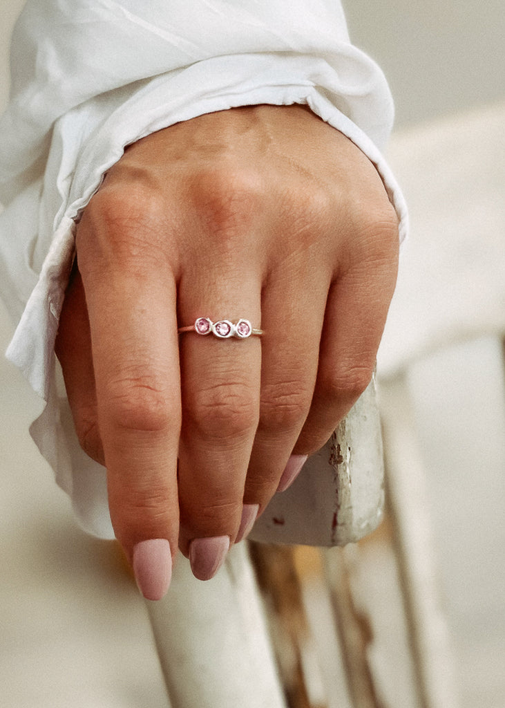 Χειροποίητο δαχτυλίδι Eday ασημί με τρεις πέτρες Swarovski ροζ, φορεμένο στο χέρι μοντέλου.