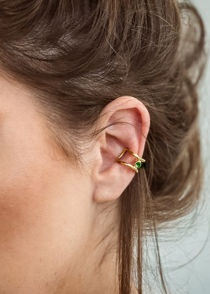 Μοντέλο που φοράει χειροποίητο ear cuff σκουλαρίκι χρυσό με μία πέτρα swarovski πρασσινη, στο αυτί.