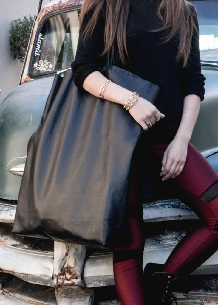 girl in front of a car with  3rd-floor handmade leather giant bag black