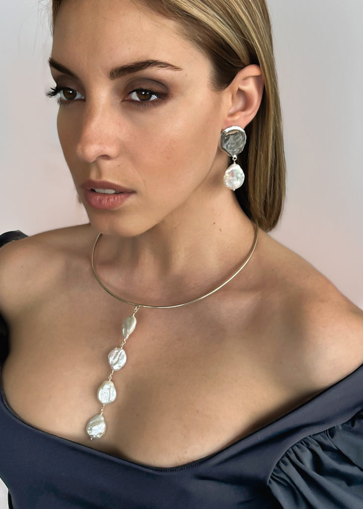 close-up of a girl with black dress, that is wearing the Theros earrings and necklace , made of sterling silver with dangling pearls