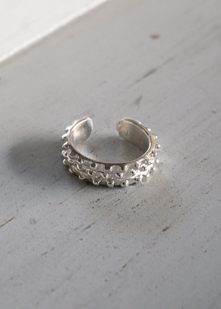 Nesrin. Silver earcuff with tiny, embossed beads around its circumference.
