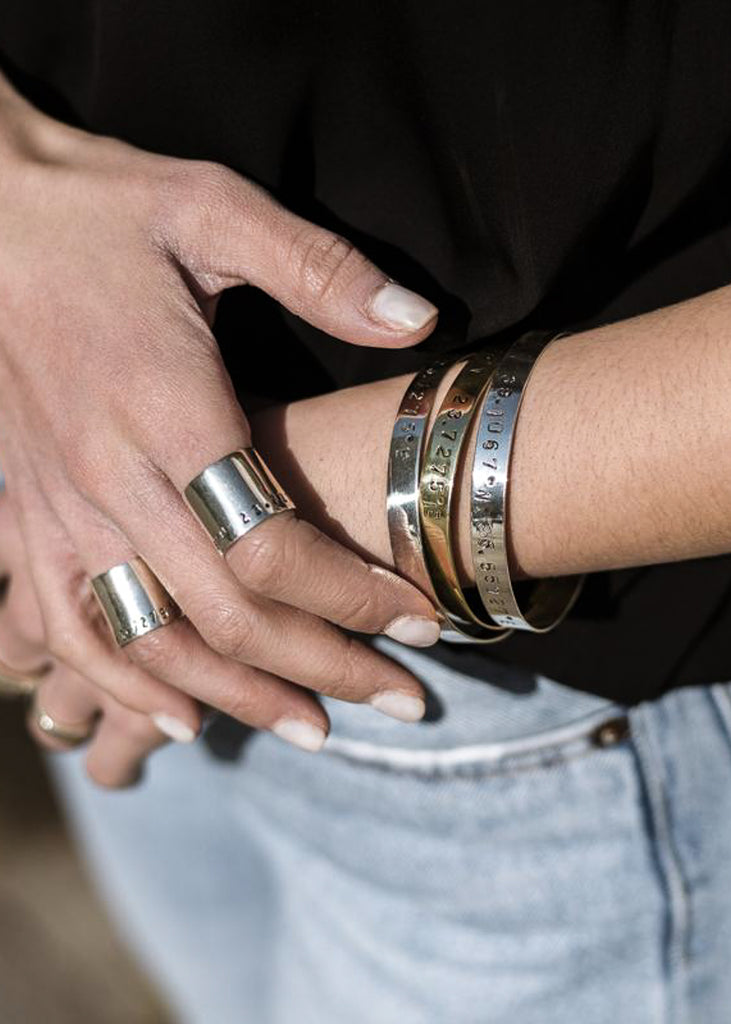 Close up of girl's hands. She is wearing handmade,silver, coordinates rings.