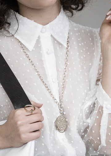 woman , wearing Phaistos disk necklace, brass -platinum plated