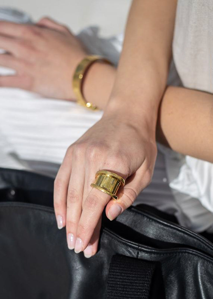 woman in white dress,with roadman wide gold plated ring by 3rd-floor