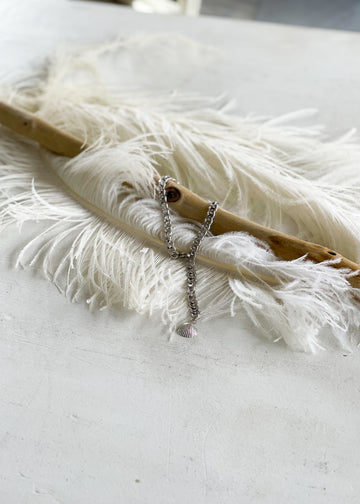 Handmade, steel chain anklet with a sheashell charm, artfully photographed on wood and feathers