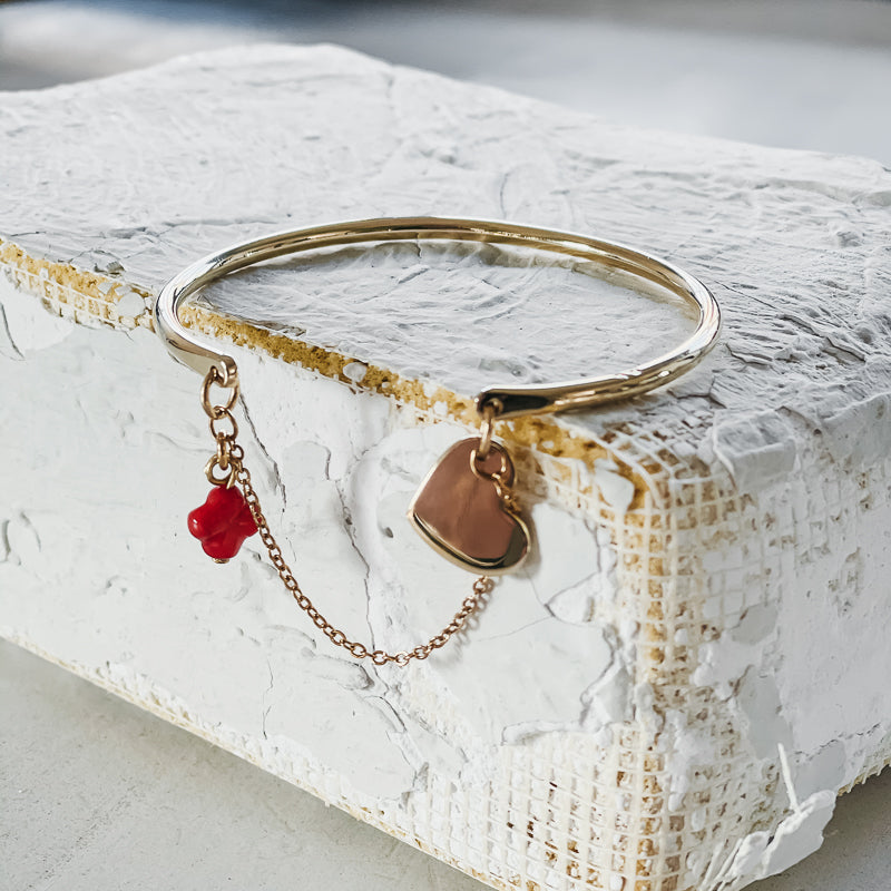 Belamour. Gold, bangle and chain bracelet, with a small, coral cross, and a small heart