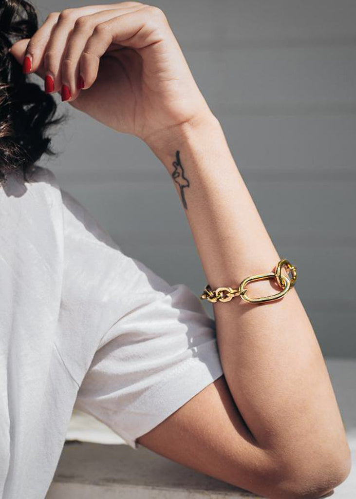 woman in white, with handmade gold bracelet, massive by 3rd-floor