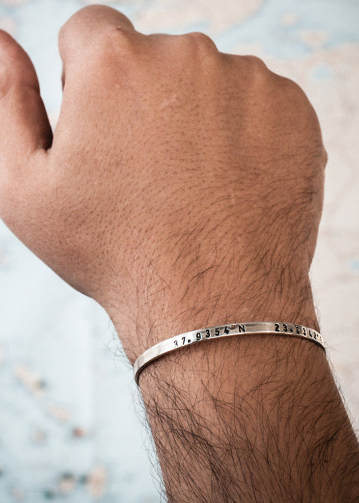 Male hand, wearing a silver, Anamnisi, handmade, coordinates bracelet