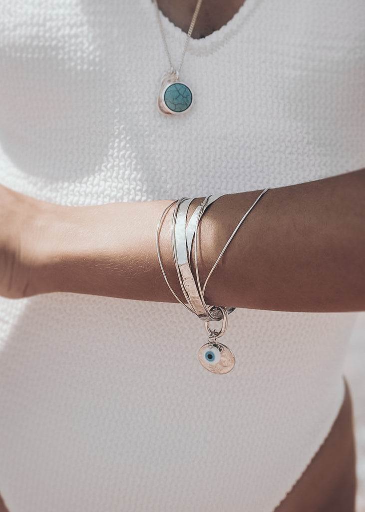 woman at the beach, wearing, Handmade Thallo bracelet, consisting of 7, uneven in size separate bracelets 