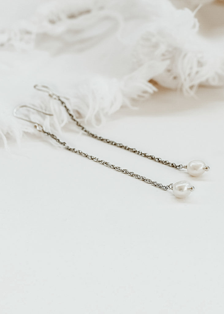 Two silver dangling earrings, with a thin long chain and a round pearl on each end, placed on a white background. | Χειροποίητα Σκουλαρίκια Forever
