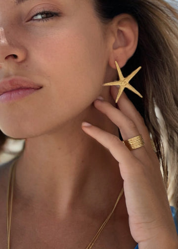 woman with 3rd floor handmade starfish earrings 