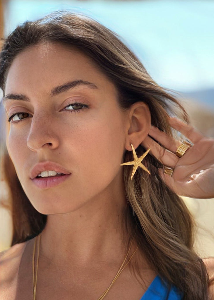 woman with 3rd floor starfish earrings gold