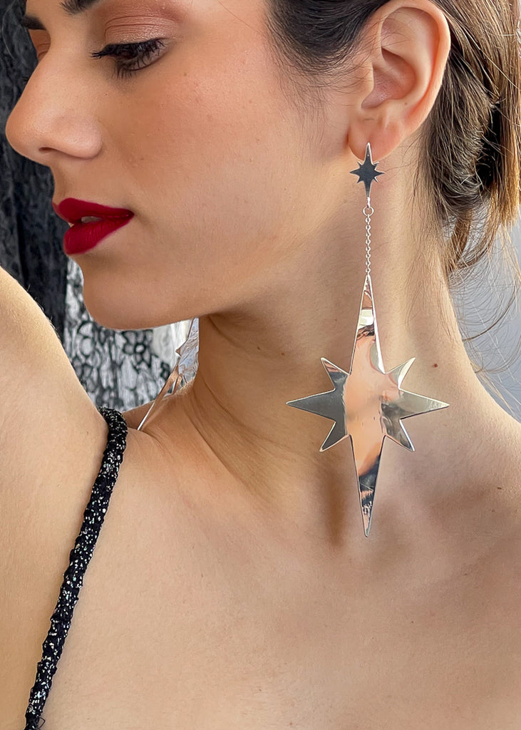 young woman wearing the big shinny earring Twinkler in the shape of a star