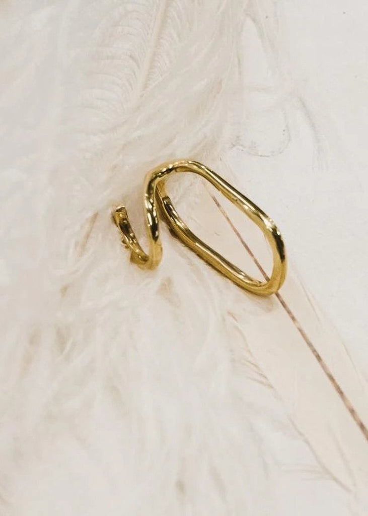Alvaro. Gold, statement ring placed on white feathers