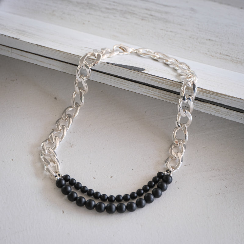 Silver curb link chain necklace, with a double string of matte, black onyx stones
