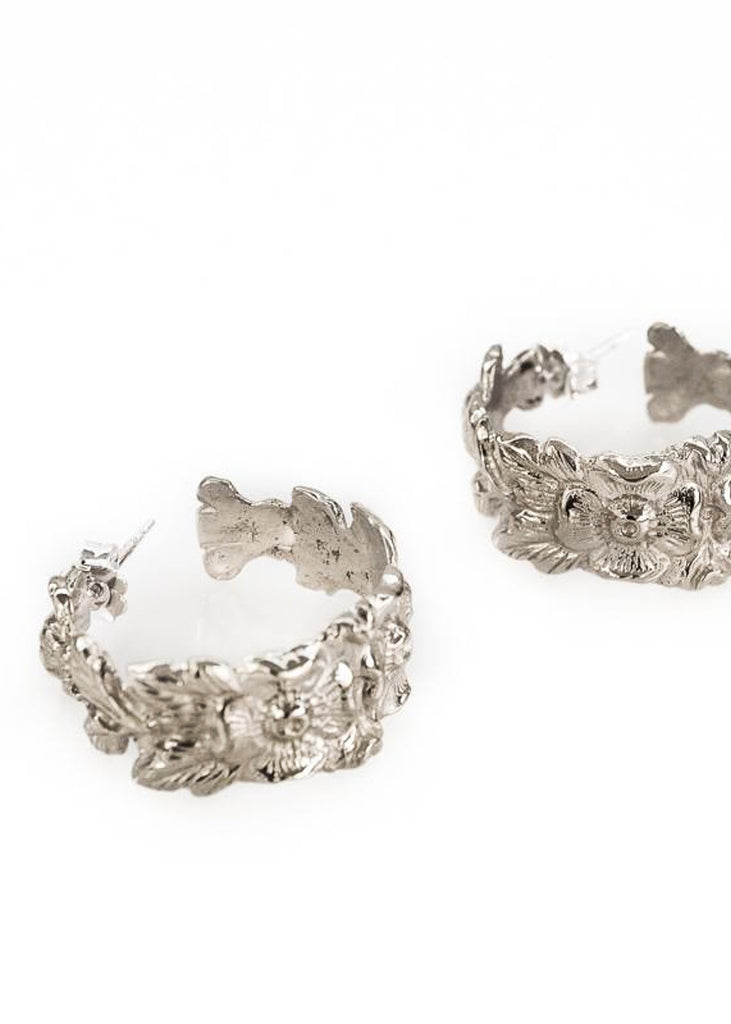 Hippolyta. Pair of silver loop earrings, with embossed, intertwined flowers