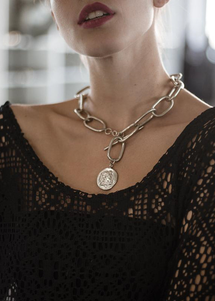 Girl in black shirt wearing an adjustable big loop chain choker embellished with a round element portraying the head of Alexander the Great