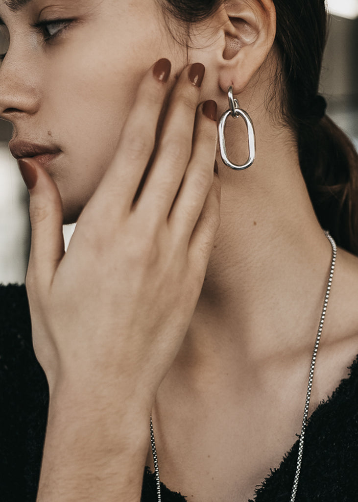 model with Massive, loop chain earrings, in silver 
