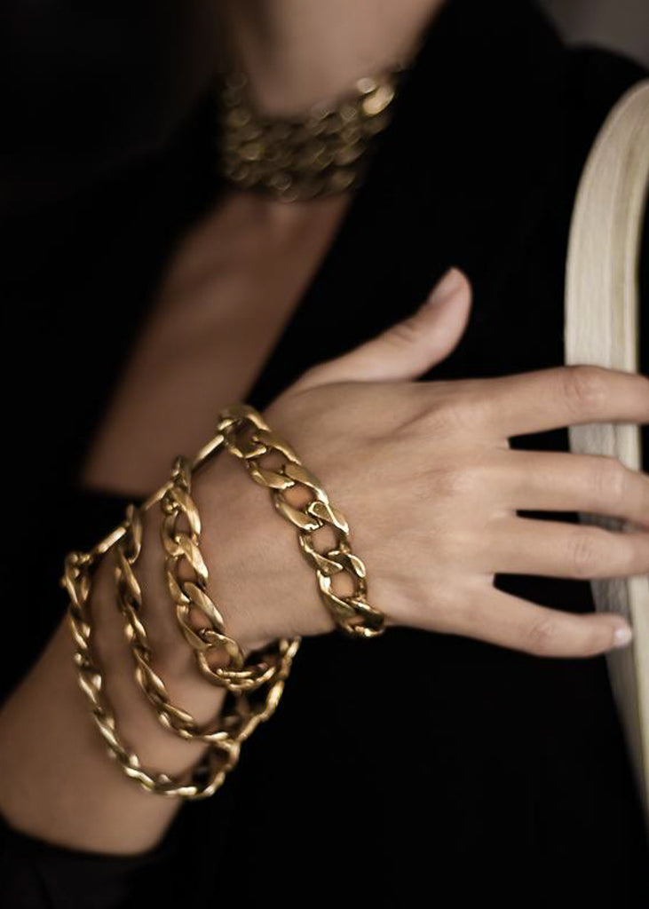 Woman's hands, she is wearing a Tetra, handmade, gold plated brass, chain bracelet.