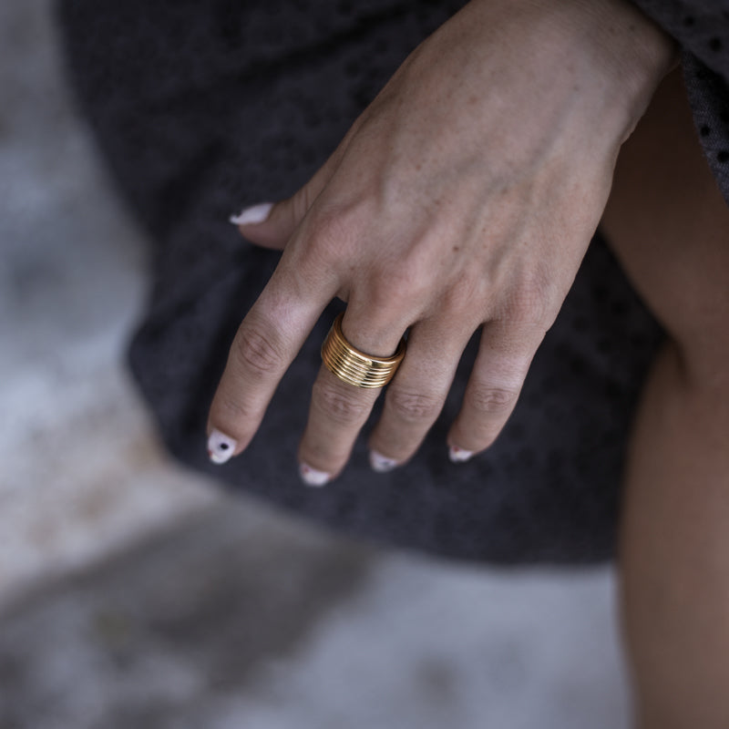 Close up of female's hand. On her middle finger, she is wearing, a Verona, handmade, gold plated ring, by 3rd Floor