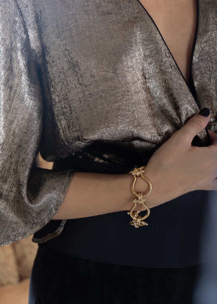 Female with, a gold, link chain bracelet