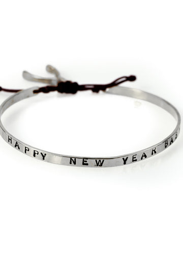 Handmade, silver plated brass, adjustable, black cord tie, charm bracelet, stamped with the phrase Happy New Year Baby