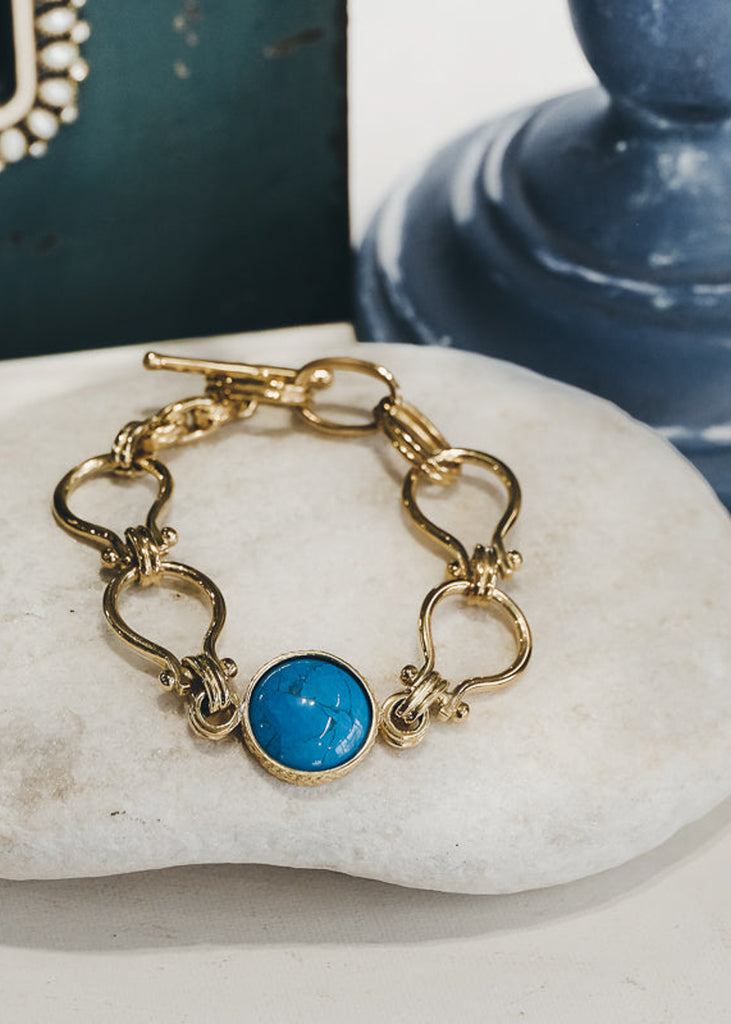 Gold, handmade link bracelet with an encased, center, turquoise stone