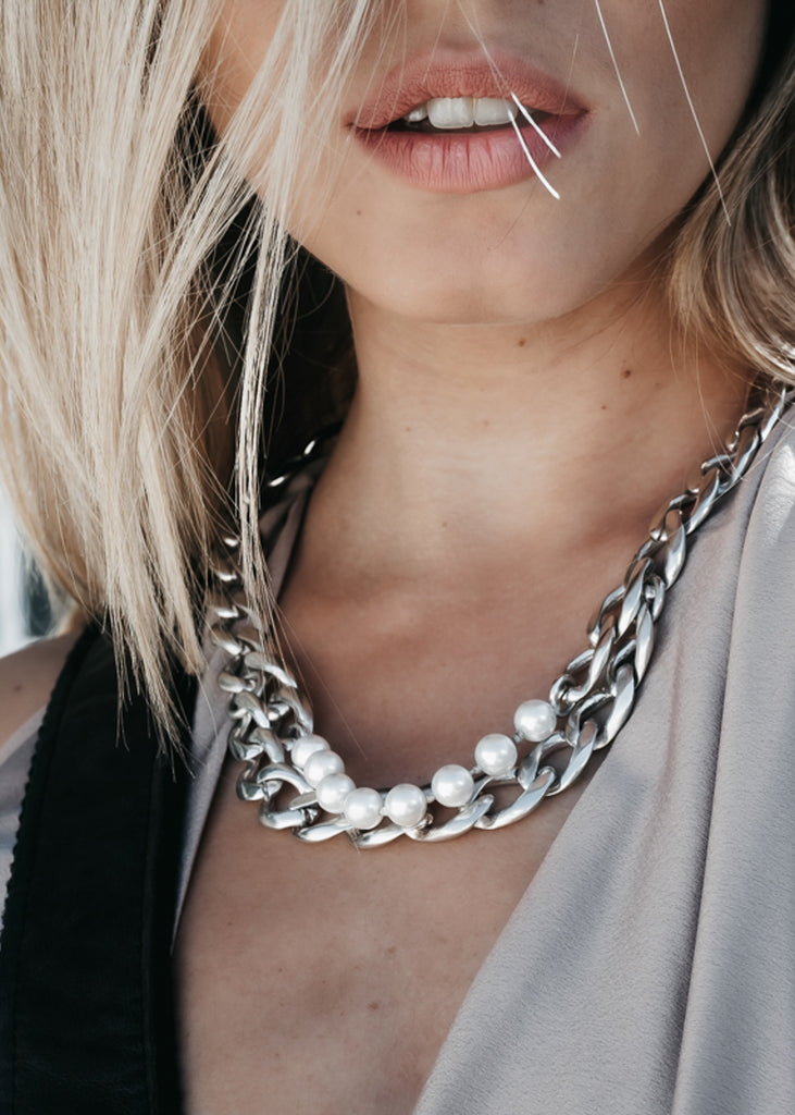 Close up of blond female's neck. She is wearing a silver chain, and pearls necklace by 3rd Floor Handmade Jewellery