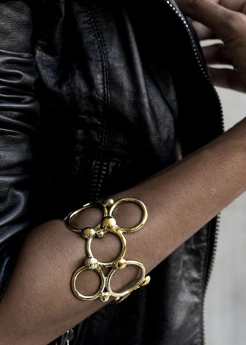 close up woman's arm with pendulum bracelet,gold,by 3rd floor 