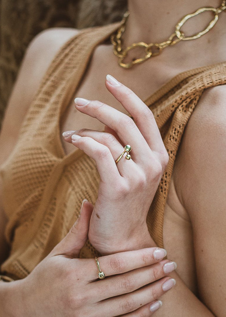 close-up woman's hand, with a handmade,pendulum ring, gold