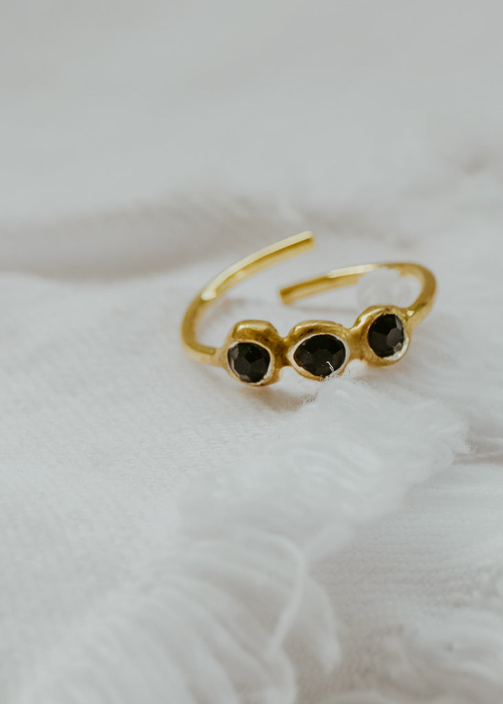 Δαχτυλίδι χειροποίητο χρυσό από ασήμι, με τρεις πέτρες Swarovski μαύρες σε λευκό φόντο.