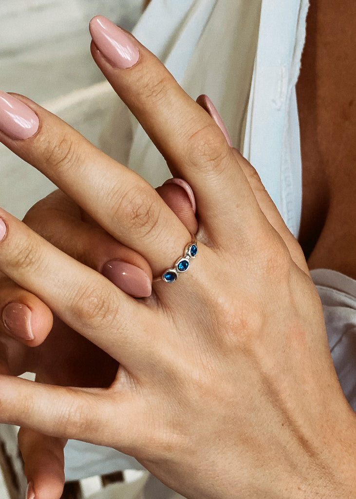 Χειροποίητο δαχτυλίδι Eday ασημί με τρεις πέτρες Swarovski μπλε, φορεμένο στο χέρι μοντέλου.