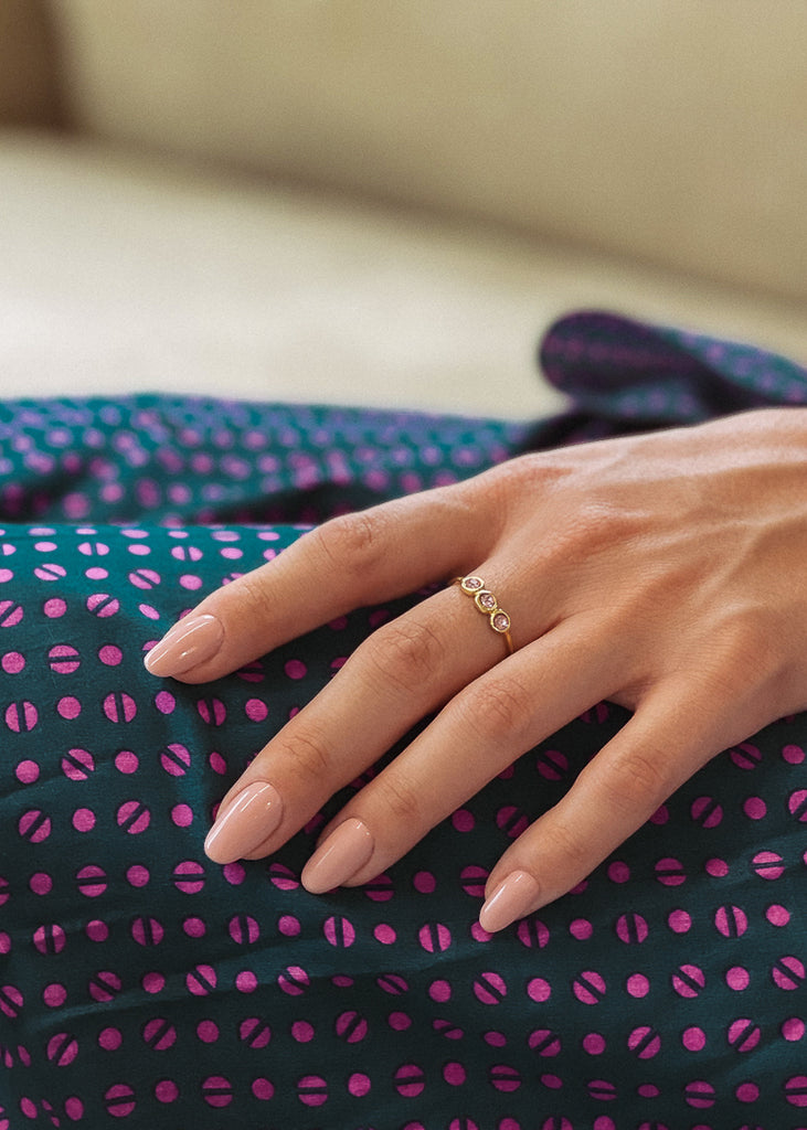 Χειροποίητο δαχτυλίδι Eday χρυσό με τρεις πέτρες Swarovski ροζ, φορεμένο στο χέρι μοντέλου.