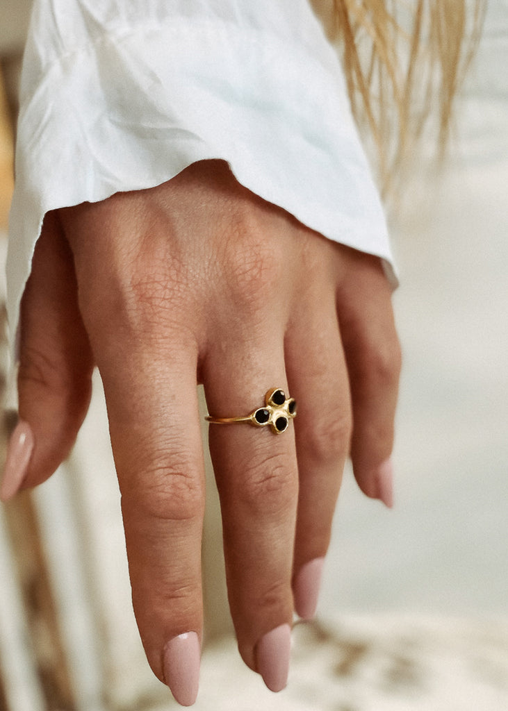 Χειροποίητο δαχτυλίδι Eday χρυσό με τέσσερεις πέτρες Swarovski μαύρες, φορεμένο στο χέρι μοντέλου.