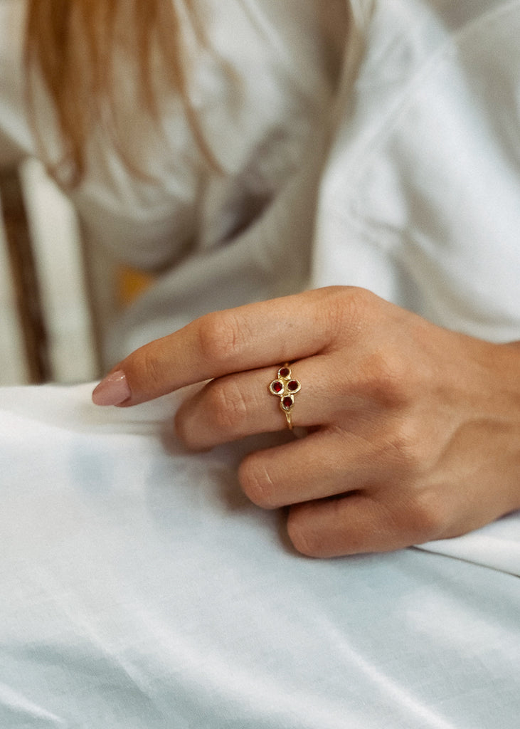 Χειροποίητο δαχτυλίδι Eday χρυσό με τέσσερεις πέτρες Swarovski μπορντό, φορεμένο στο χέρι μοντέλου.