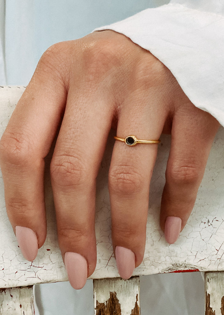 Χειροποίητο δαχτυλίδι Eday χρυσό με μία πέτρα swarovksi μαύρη, φορεμένο στο χέρι μοντέλου.