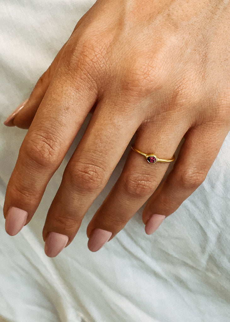 Χειροποίητο δαχτυλίδι Eday χρυσό με μία πέτρα swarovksi κόκκινη, φορεμένο στο χέρι μοντέλου.