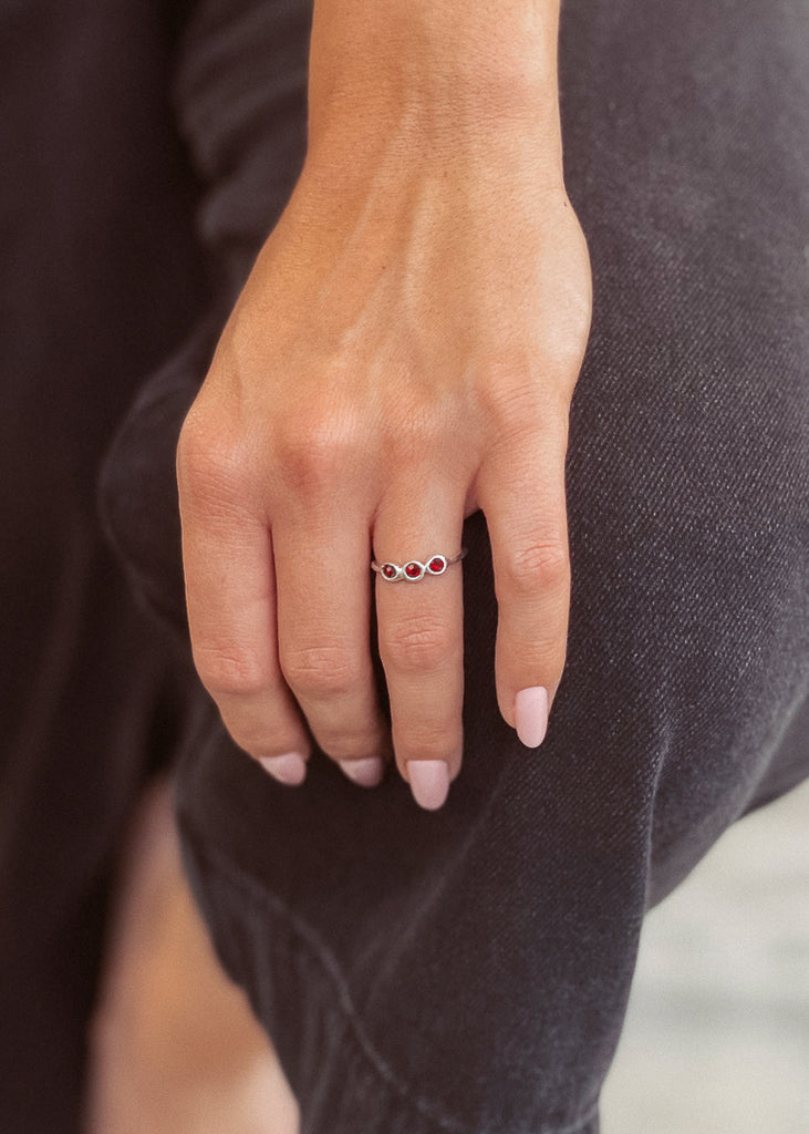Μοντέλο που φοράει χειροποίητο δαχτυλίδι λεπτό ασημί, με τρεις πέτρες κόκκινες Swarovksi.