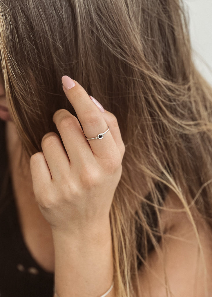 Μοντέλο που φοράει χειροποίητο δαχτυλίδι λεπτό ασημί, με μια μαύρη πέτρα swarovski.