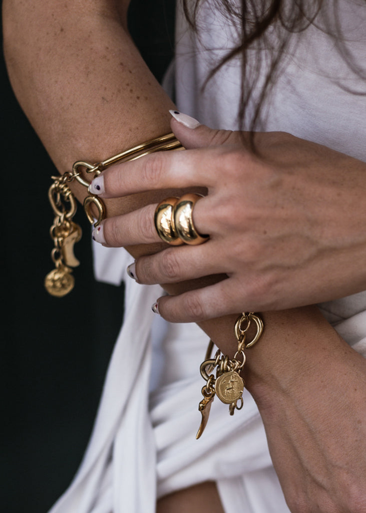 woman in white dress. She is wearing, a Meliora, gold, handmade ring. Ring made in Athens, by 3rd-Floor Workshop