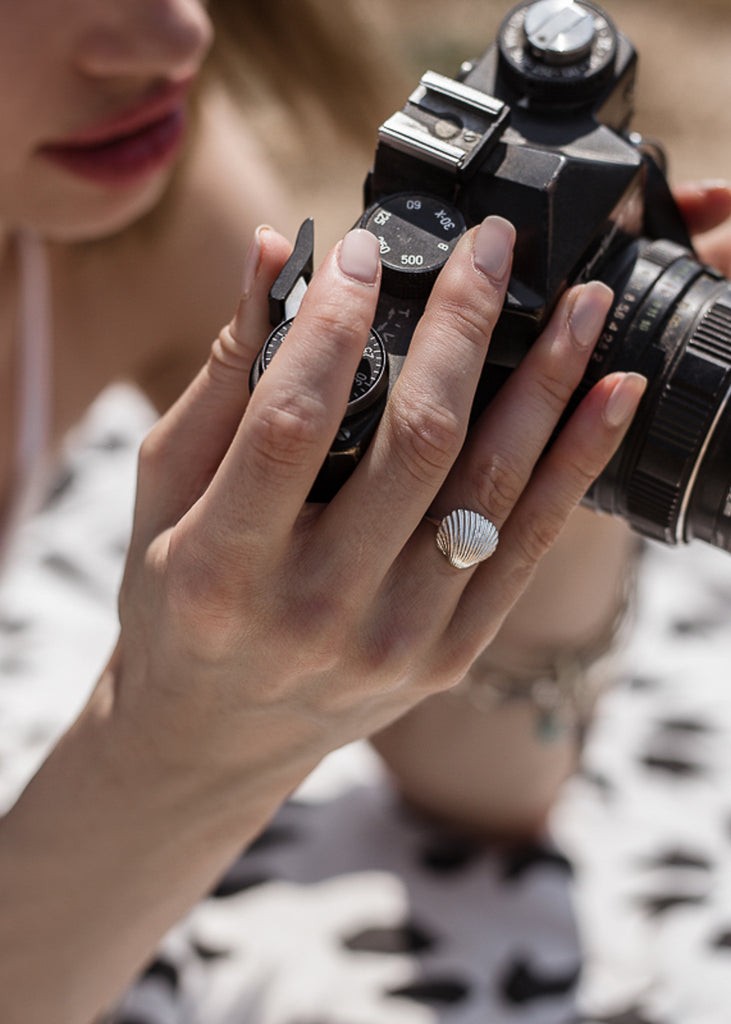 woman holding a camera, with 3rd floor handmade jewellery ring seashell silver