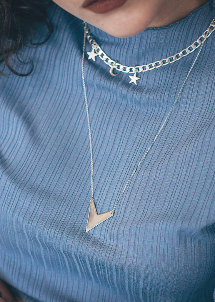 blonde girl wearing arrow necklace silver 